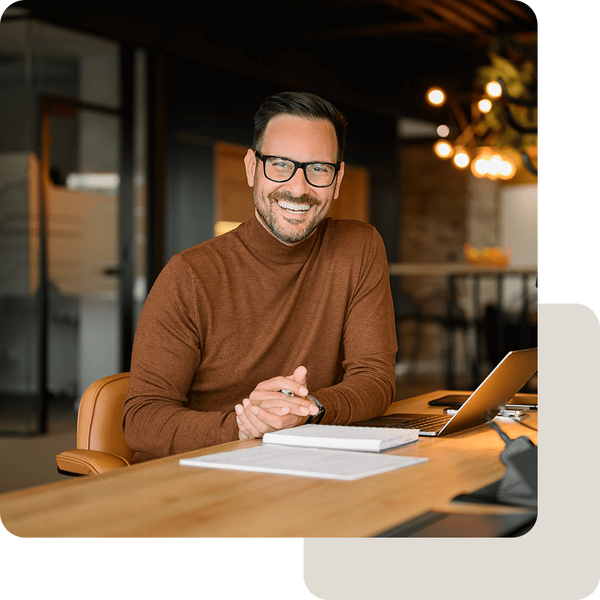 Mann arbeitet im Homeoffice mit Notebook und Unterlagen