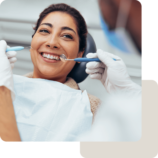 Lächelnde Frau bei einer zahnärztlicher Behandlung in der Zahnarztpraxis